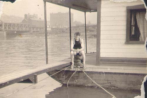 Scanned photo of young man sitting on houseboat.