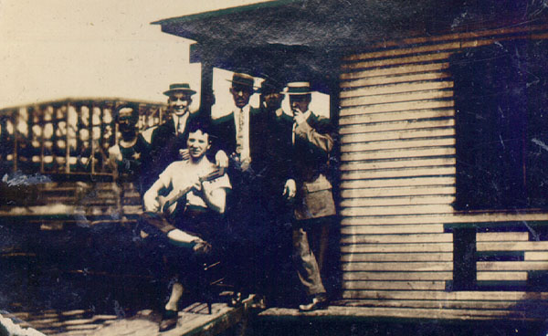 Scanned photo of men on houseboat.