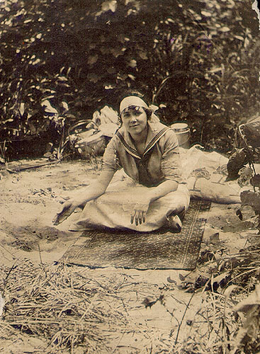 Scanned photo of young woman seated on the ground.