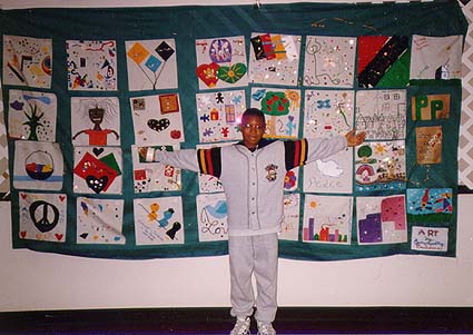 Young man in
front of quilt at '96 conference.